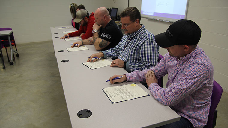 Spring 2019 manufacturing apprenticeship participants preparing to sign their agreement.